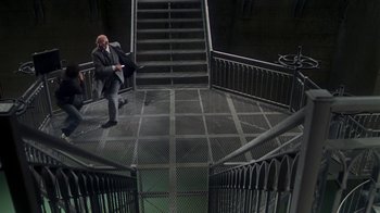 Movie still from “Marathon Man” (1976), directed by John Schlesinger – A man in a suit is sitting on a staircase; Extreme Wide shot, Overhead angle