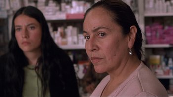 Movie still from “Maria Full of Grace” (2004), directed by Joshua Marston – A woman in a pink shirt is looking at the camera; Close Up shot, Over the shoulder angle