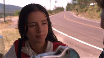 Movie still from “Maria Full of Grace” (2004), directed by Joshua Marston – A woman standing on the side of a road with a bicycle; Close Up shot, Low angle