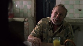Movie still from “Maria Full of Grace” (2004), directed by Joshua Marston – A man sitting at a table with a glass of orange juice in front of him; Close Up shot, Over the shoulder angle