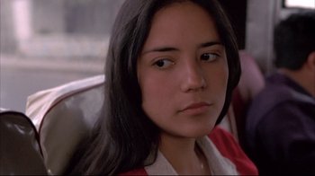 Movie still from “Maria Full of Grace” (2004), directed by Joshua Marston – A young woman sitting on a train looking into the camera; Close Up shot, Over the shoulder angle
