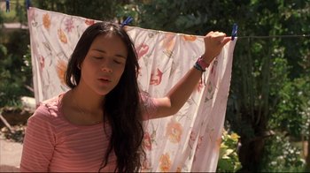 Movie still from “Maria Full of Grace” (2004), directed by Joshua Marston – A woman holding a pair of blue shears over her head; Close Up shot, Low angle