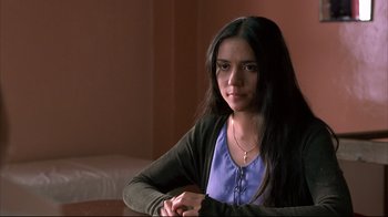 Movie still from “Maria Full of Grace” (2004), directed by Joshua Marston – A woman sitting in front of a bed in a room; Close Up shot, Over the shoulder angle