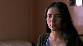 Movie still from “Maria Full of Grace” (2004), directed by Joshua Marston – A woman with a necklace is looking at the camera; Close Up shot, Over the shoulder angle