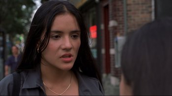 Movie still from “Maria Full of Grace” (2004), directed by Joshua Marston – A woman with long black hair standing on the sidewalk; Close Up shot, Over the shoulder angle