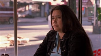 Movie still from “Maria Full of Grace” (2004), directed by Joshua Marston – A woman sitting on a bench in the sunlight; Close Up shot, High angle