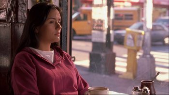 Movie still from “Maria Full of Grace” (2004), directed by Joshua Marston – A woman sitting in front of a window holding a coffee cup; Medium shot, Low angle