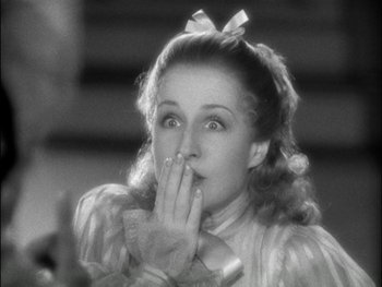 Movie still from “Marie Antoinette” (1938), directed by Julien Duvivier – A young woman with her hand over her mouth; Close Up shot, Over the shoulder angle