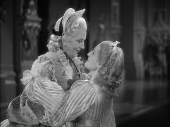 Movie still from “Marie Antoinette” (1938), directed by Julien Duvivier – Two women dressed in period costumes are embracing; Medium shot, Over the shoulder angle