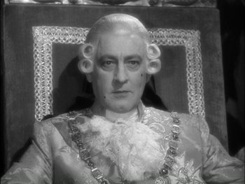 Movie still from “Marie Antoinette” (1938), directed by Julien Duvivier – An old photo of an older man in a suit; Close Up shot, High angle