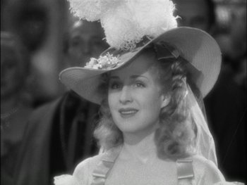 Movie still from “Marie Antoinette” (1938), directed by Julien Duvivier – A black and white photo of a woman wearing a hat; Close Up shot, Over the shoulder angle