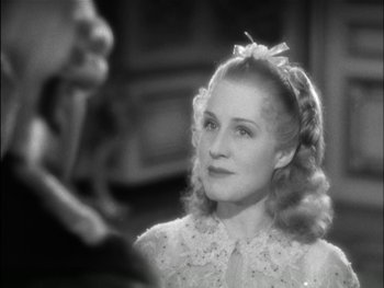 Movie still from “Marie Antoinette” (1938), directed by Julien Duvivier – A woman with a bow in her hair looking to her left; Close Up shot, Over the shoulder angle