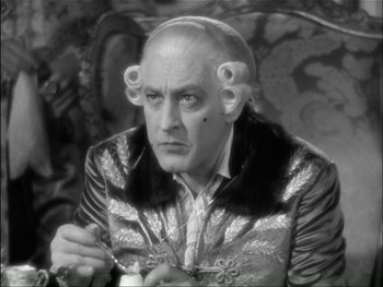 Movie still from “Marie Antoinette” (1938), directed by Julien Duvivier – An older man in a black and white photo; Close Up shot, High angle