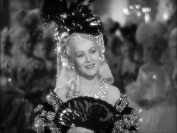 Movie still from “Marie Antoinette” (1938), directed by Julien Duvivier – A black and white photo of a woman with a fan; Close Up shot, Over the shoulder angle