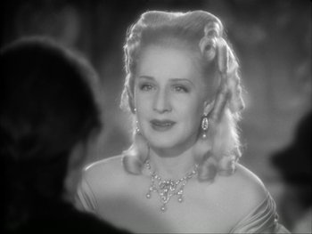 Movie still from “Marie Antoinette” (1938), directed by Julien Duvivier – An old photo of a woman in a formal dress; Close Up shot, Over the shoulder angle