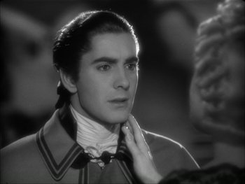 Movie still from “Marie Antoinette” (1938), directed by Julien Duvivier – A man in a suit and tie looking at the camera; Close Up shot, Over the shoulder angle