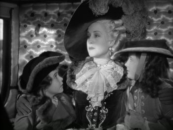 Movie still from “Marie Antoinette” (1938), directed by Julien Duvivier – A woman in a large hat with two other women; Medium shot, High angle