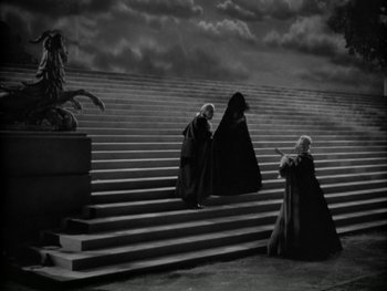 Movie still from “Marie Antoinette” (1938), directed by Julien Duvivier – A group of people standing next to each other on some steps; Wide shot, High angle