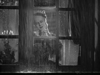 Movie still from “Marie Antoinette” (1938), directed by Julien Duvivier – A woman sitting at a window looking out of a window; Medium shot, High angle