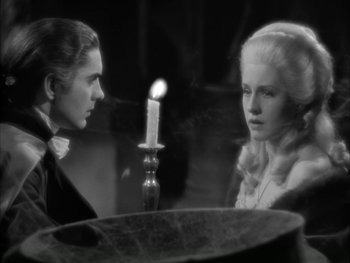 Movie still from “Marie Antoinette” (1938), directed by Julien Duvivier – A man and a woman staring at each other in front of a lit candle; Medium shot, High angle