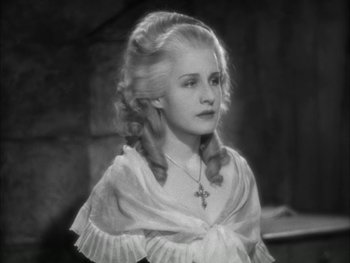 Movie still from “Marie Antoinette” (1938), directed by Julien Duvivier – An old photo of a woman in a white dress; Close Up shot, High angle