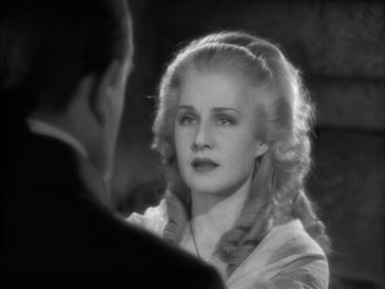 Movie still from “Marie Antoinette” (1938), directed by Julien Duvivier – A woman with long blonde hair is looking at a man with long blonde hair; Close Up shot, Over the shoulder angle