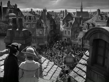 Movie still from “Marie Antoinette” (1938), directed by Julien Duvivier – A black - and - white photo of a crowd of rooftops; Extreme Wide shot, High angle