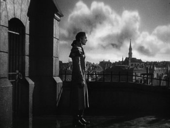Movie still from “Marie Antoinette” (1938), directed by Julien Duvivier – A black and white photo of a woman standing on a balcony; Wide shot, Low angle