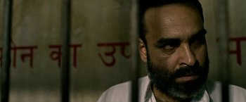 Movie still from “Extraction” (2020), directed by Sam Hargrave – A man with a goatee and a beard; Close Up shot, Low angle