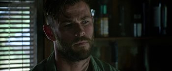 Movie still from “Extraction” (2020), directed by Sam Hargrave – A person with a beard; Close Up shot, Over the shoulder angle