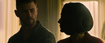 Movie still from “Extraction” (2020), directed by Sam Hargrave – A man and a woman standing next to each other; Close Up shot, Over the shoulder angle
