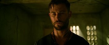 Movie still from “Extraction” (2020), directed by Sam Hargrave – A person with a beard; Close Up shot, Over the shoulder angle