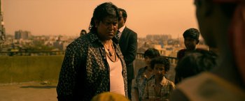 Movie still from “Extraction” (2020), directed by Sam Hargrave – A group of people standing on top of a building; Medium shot, Low angle