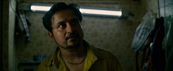 Movie still from “Extraction” (2020), directed by Sam Hargrave – A person wearing a yellow shirt; Close Up shot, Low angle