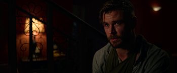 Movie still from “Extraction” (2020), directed by Sam Hargrave – A person with a beard; Close Up shot, Over the shoulder angle