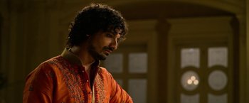 Movie still from “Extraction” (2020), directed by Sam Hargrave – A man in a red shirt is looking down; Close Up shot, Low angle