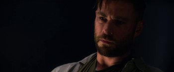 Movie still from “Extraction” (2020), directed by Sam Hargrave – A person with a beard; Close Up shot, Over the shoulder angle