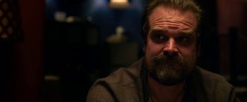 Movie still from “Extraction” (2020), directed by Sam Hargrave – A man with a goatee and a beard; Close Up shot, Over the shoulder angle