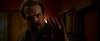 Movie still from “Extraction” (2020), directed by Sam Hargrave – A person with a beard; Close Up shot, Over the shoulder angle