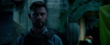 Movie still from “Extraction” (2020), directed by Sam Hargrave – A person wearing a vest; Close Up shot, Over the shoulder angle