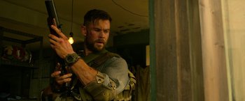 Movie still from “Extraction” (2020), directed by Sam Hargrave – A person holding a flashlight; Medium shot, Over the shoulder angle