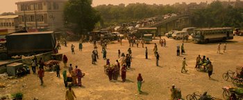Movie still from “Extraction” (2020), directed by Sam Hargrave – A group of people standing in the dirt; Extreme Wide shot, High angle