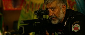 Movie still from “Extraction” (2020), directed by Sam Hargrave – A person with a gun; Close Up shot, Over the shoulder angle