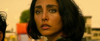 Movie still from “Extraction” (2020), directed by Sam Hargrave – A woman's face with a lot of make - up; Close Up shot, High angle