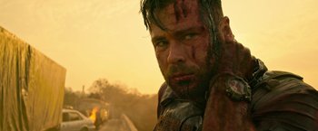 Movie still from “Extraction” (2020), directed by Sam Hargrave – A person with a beard; Close Up shot, Over the shoulder angle