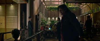 Movie still from “Extraction” (2020), directed by Sam Hargrave – A group of people sitting in a room; Medium shot, Over the shoulder angle