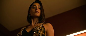 Movie still from “Extraction” (2020), directed by Sam Hargrave – A woman in a black and gold dress; Close Up shot, Low angle