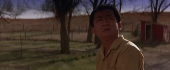 Movie still from “Mars Attacks!” (1996), directed by Tim Burton – A man standing in front of some trees and a fence; Close Up shot, Low angle