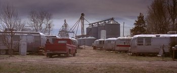 Movie still from “Mars Attacks!” (1996), directed by Tim Burton – A group of vehicles parked next to each other in a field; Extreme Wide shot, High angle