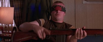 Movie still from “Mars Attacks!” (1996), directed by Tim Burton – A man with a blindfold on holding a rifle; Close Up shot, Low angle